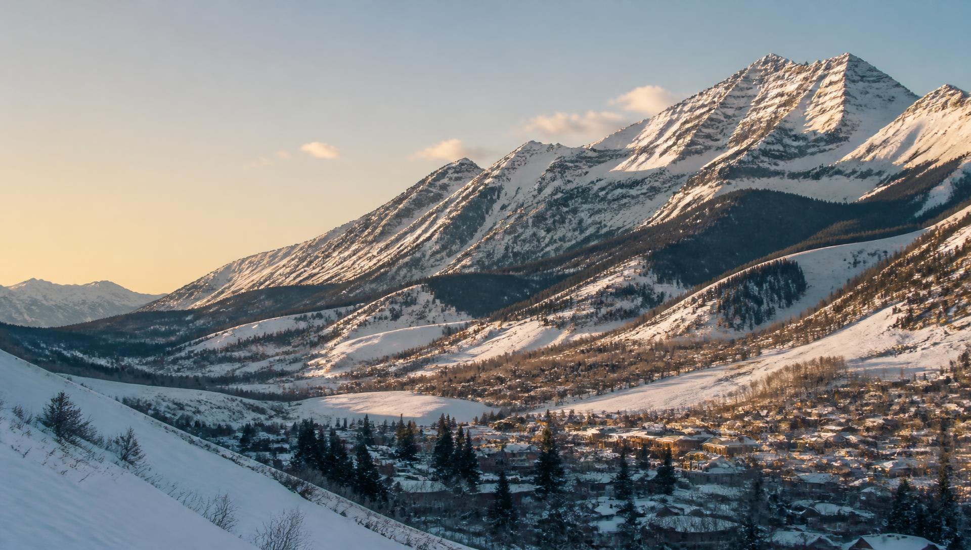 Snow-covered Colorado mountain valley above a small alpine town at golden hour